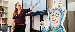 Eine Lehrkraft erklärt ein Wort auf Deutsch