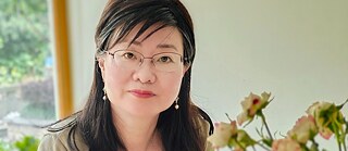 Portrait photo of a woman with glasses and long dark hair.