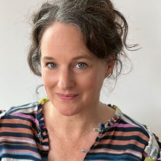 Porträtfoto der Autorin Nicole Seifert, sie trägt ein geringeltes Oberteil und schaut leicht lächelnd in die Kamera.