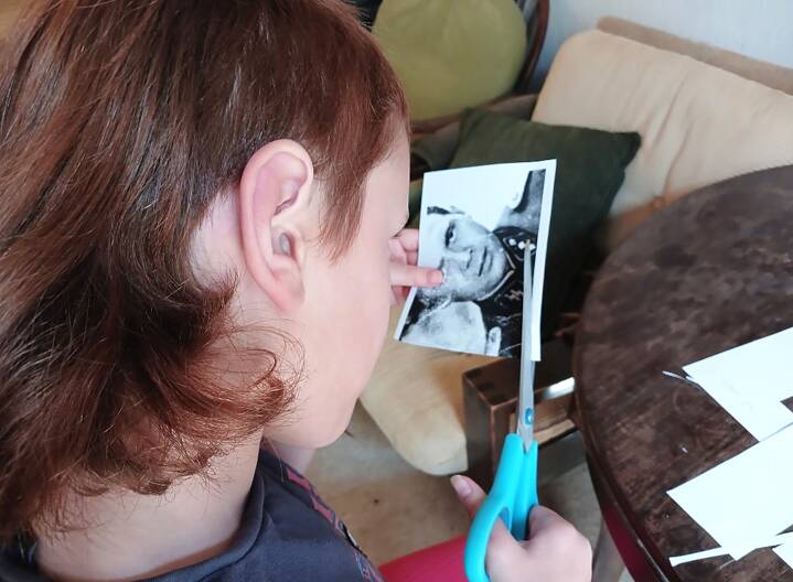 Ein Kind schneidet ein Foto aus