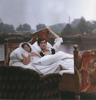 Un homme et une femme sont posés sur un lit devant un fleuve