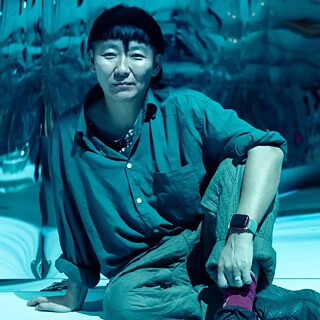 A portrait of Anne Duk Hee Jordan in blue colours