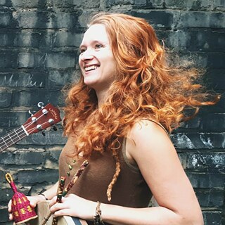 Rothaarige lachende Frau Irene Hoffmann mit Ausschnitt einer Gitarre