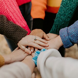 Група людей, що тримаються за руки, символізуючи єдність та солідарність.