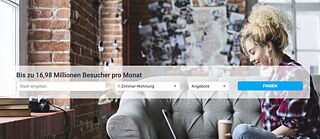 Frau sitzt auf Couch mit Laptop