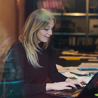 Eine Frau sitzt am Schreibtisch