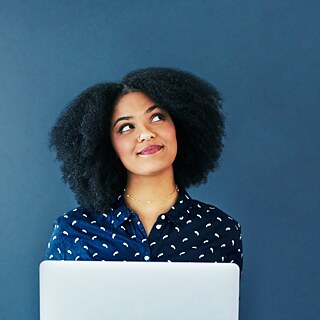 Goethe-Institut translation funding - A lady sitting with her laptop, looking up thoughtfully