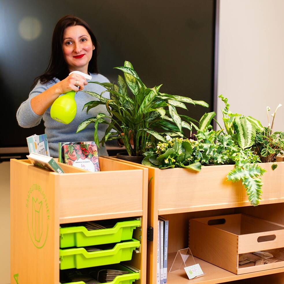 Ольга Дубова поливає рослини бібліотеки Goethe-Institut в Києві.