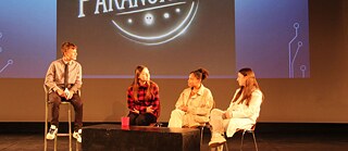 4 Schüler*innen debattieren auf der Bühne