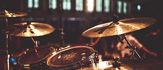 Nahaufnahme eines Schlagzeugs auf einer Bühne, beleuchtet von warmem Licht