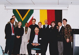 Personen von links nach rechts. Peter Bafana Mahlangu (Techniker und Fahrer), dahinter halb-verdeckt Walter Hassmann (Kulturreferent deutschen Botschaft Pretoria), Wiebke Wilhelm-Makgabo (Empfang), Khutso Makgabo (Deutschlehrer), Praktikant (Name unbekannt), sitzend Dr. Matthias Rick (Institutsleiter), Susan Sandison (Verwaltungsleiterin), Stefan Hüsgen (Leitung Sprachabteilung), Elna Coetzer (Management Sprachkurse), Abel Farao (Deutschlehrer), Marina Snyman (Informationszentrum)