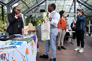 Two people talk at the information table of the Sub-Saharan Africa region