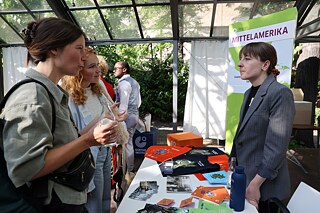 Two women enquire at the information table of the Central America region