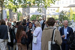 Teilnehmer der Veranstaltung stehen zusammen und unterhalten sich