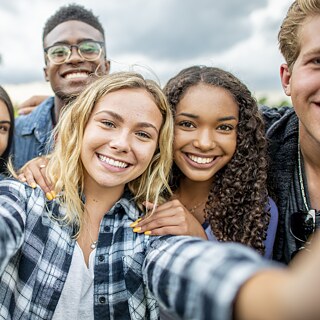 Jugendliche lächeln in die Kamera.