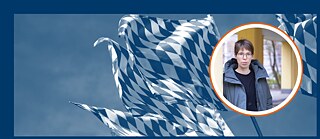 Im Hintergrund sieht man die Fahnen Bayerns im Wind wehen. Im Vordergrund ist ein Bild mit der Autorin Bettina Wilpert. Sie ist weiß, trägt kurze braune Haare, eine dicke Jacke über einem Shirt und Brille.