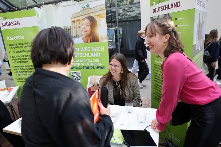 Welcome Coaches Lisa Beck and Christine Hahn (Goethe-Institut, f.l.t.r.) answer questions about their programmes in Germany at one of the ten informational stands. 