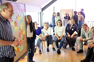 Helmut Frielinghaus (Goethe-Institut) und Quan-Minh Bottrill-Chau (Landeshauptstadt München) diskutieren in einem Workshop Fachkräftestrategien in Kommunen am Beispiel der Landeshauptstadt München.