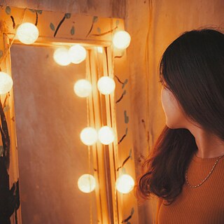 Ein Mädchen schaut in einen Spiegel.