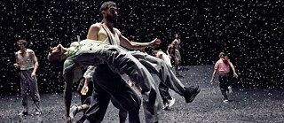 Des danseurs sont sur scène et des confettis tombent sur eux.