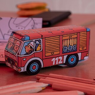 Ein Spielzeugfeuerwehrauto auf einem Tisch.