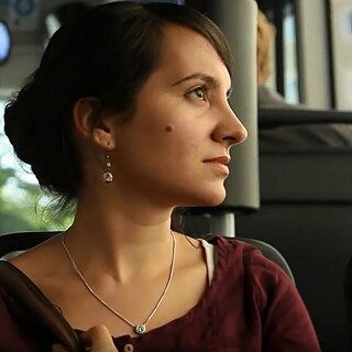 Die junge Frau Nevin sitzt im Bus und sieht aus dem Fenster.