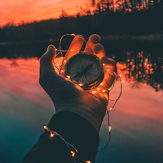 Eine Hand mit einem Kompass.