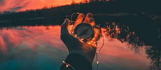 Eine Hand mit einem Kompass.