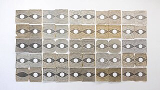 Zahlreiche Papierkreise in verschiedenen Farben, die in einer quadratischen Form angeordnet sind und ein visuell ansprechendes Muster bilden.