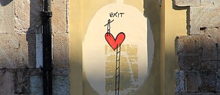 Graffiti auf dem ein Strichmännchen über eine Leiter zu einem Herz gelangt. 