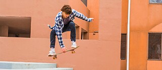 Ein Skateboarder springt über eine Treppe.