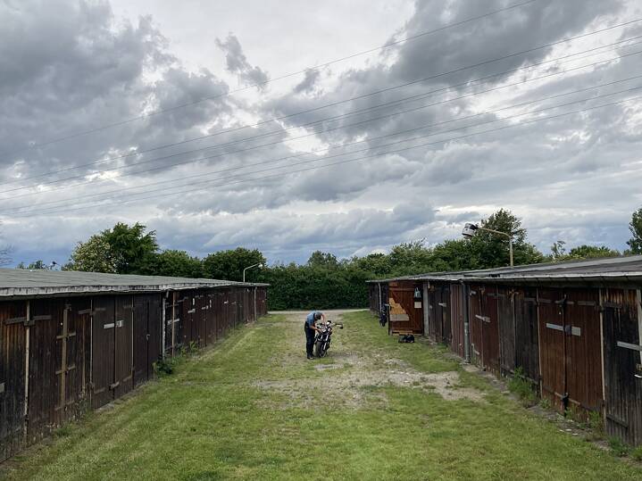 In der Mitte: Ein Mann poliert sein Motorrad vor seiner Garage