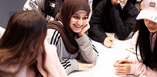Pupils at their desks discussing with each other 