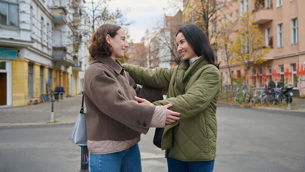 Zwei Frauen umarmen sich zur Begrüßung.