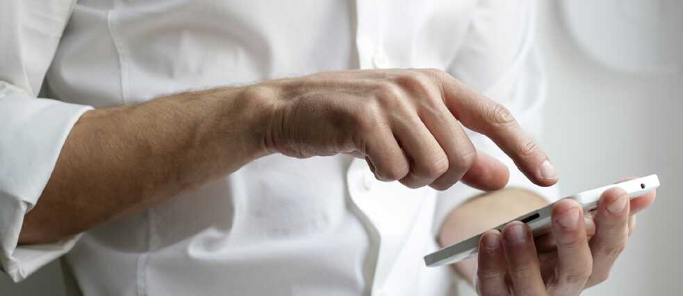 Close-up of a person using a smartphone with both hands.