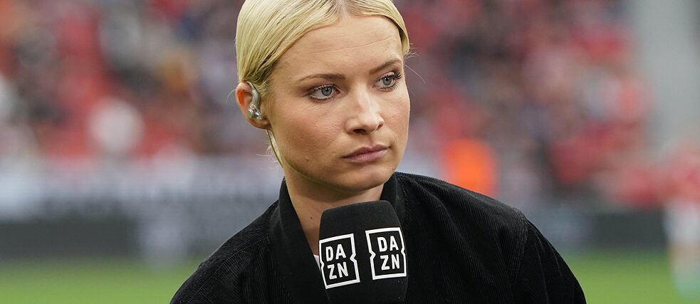Lena Cassel hält ein Mikrofon mit dem Logo von Streaming-Anbieter DAZN