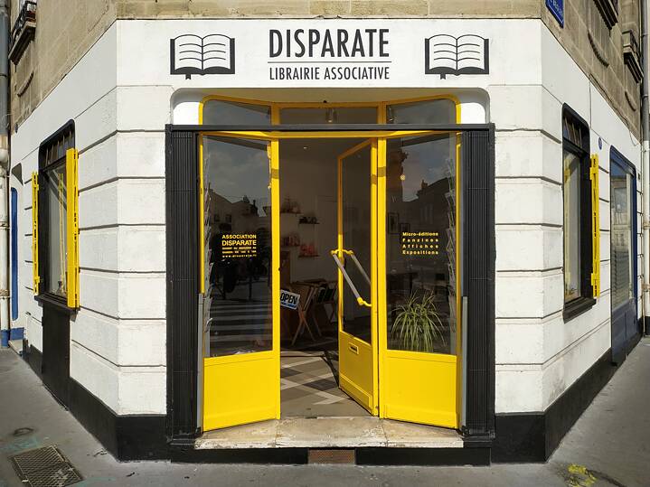 Auf dem Foto sieht man den gelbfarbigen Eingang zur Buchhandlung Disparate
