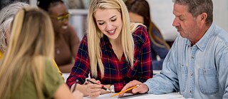 Kursteilnehmer im Klassenraum mit Lernmaterialien