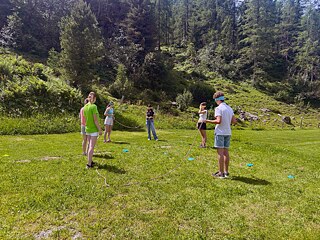 Jugendliche spielen auf einer Wiese.