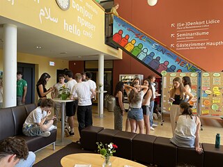 Jugendliche stehen in kleinen Gruppen zusammen und unterhalten sich.