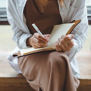Person writes in a book