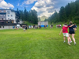 Jugendliche auf einer Wiese im Dreibeinlauf