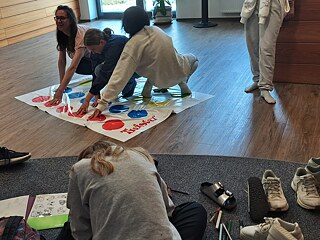 Jugendliche spielen auf dem Fußboden.