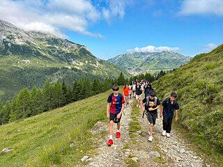 Jugendliche auf einem Wanderweg in den Alpen