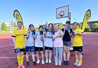 PASCH-Schülerinnen posieren für ein Gruppenfoto vor BvB Flaggen.