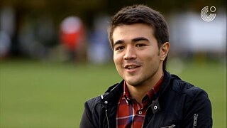 Yigit sitzt im Grünen