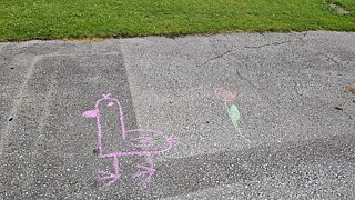 Mit Kreide gemalte Figuren auf einem gepflasterten Hof