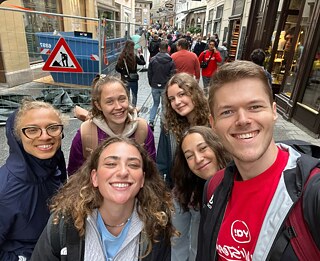 Junge Menschen bei einem Selfie vor einer Baustelle in den Straßen Salzburgs
