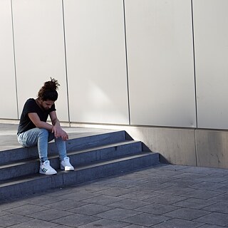Mann sitzt auf einer Treppe