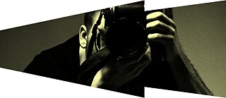 Person hält eine Kamera in Aufnahmehaltung, in Sepiaton, und verweist auf die Welt des Fotojournalismus.